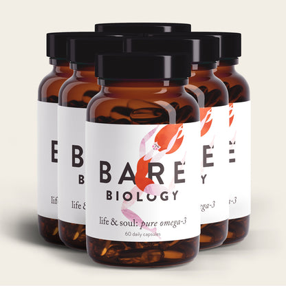 Five brown glass bottles with black caps, labeled Bare Biology, are staggered. The labels read Life & Soul Omega-3 Fish Oil Daily Capsules: 60 capsules supporting brain and heart health. The background is a light cream color.
