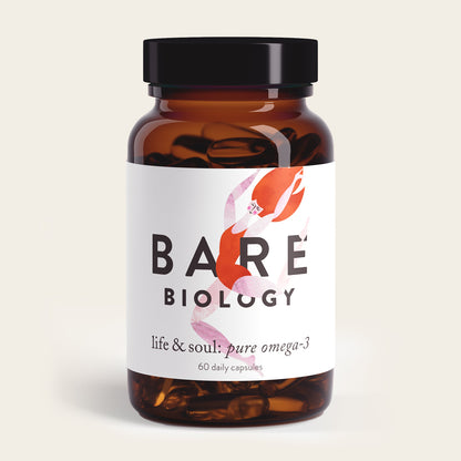 A brown glass bottle labeled Life & Soul Omega-3 Fish Oil Daily Capsules from Bare Biology contains 60 capsules promoting brain and heart health. The label has an abstract pink and red design, topped with a black screw cap.