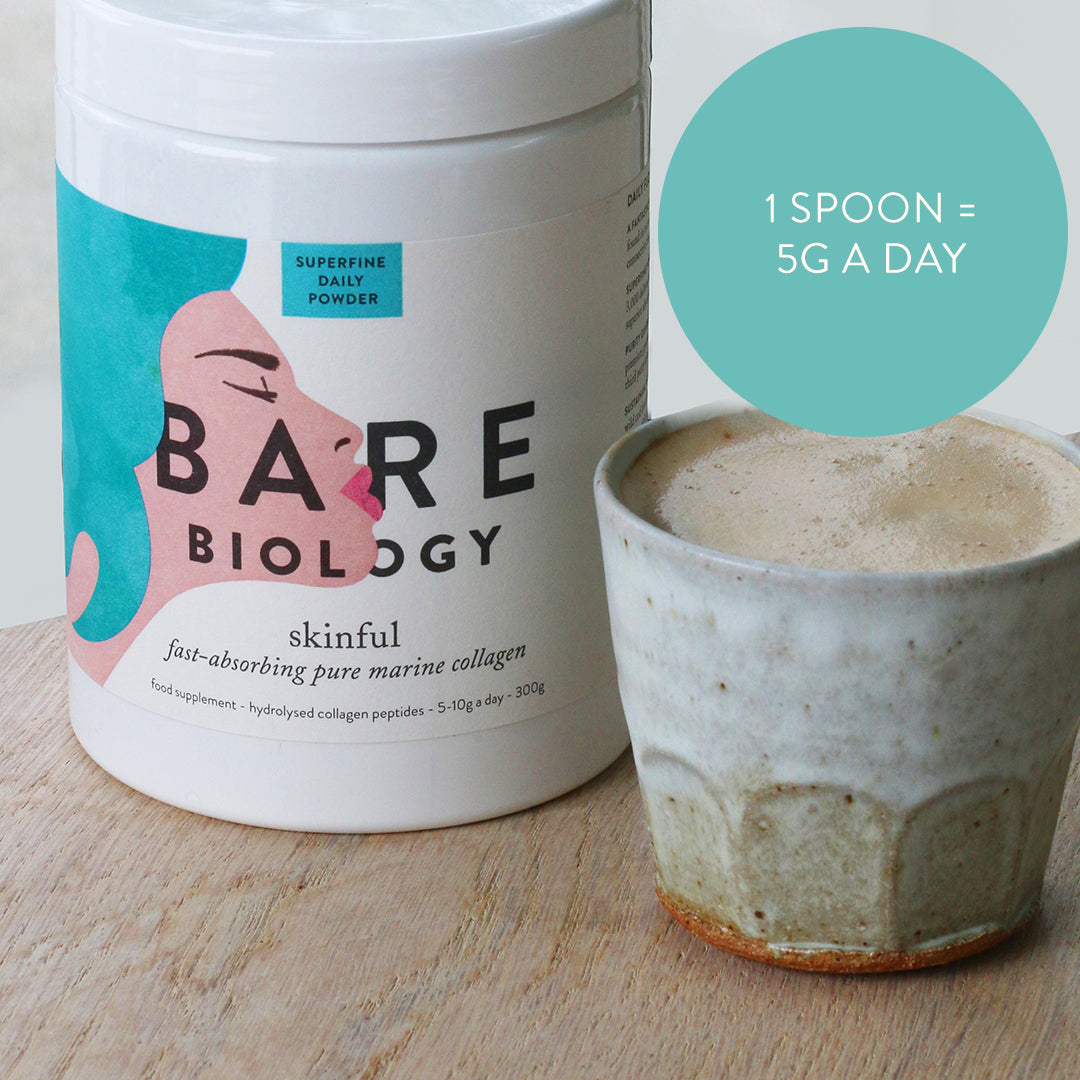 Skinful marine collagen tub on a wooden table next to a mug of coffee and a turquoise circle with dose advice: 1 spoon: 5G a day