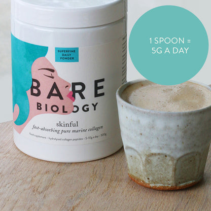 Skinful marine collagen tub on a wooden table next to a mug of coffee and a turquoise circle with dose advice: 1 spoon: 5G a day