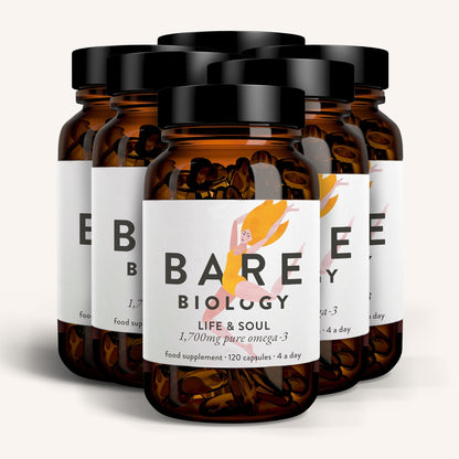 Multiple bottles of Bare Biology supplements with black lids on a white background