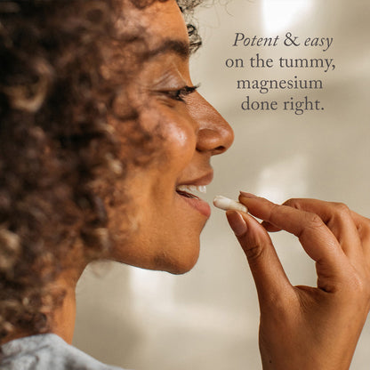 A woman with curly hair smiles while holding a white capsule. Text reads: Bare Biology Magnesium Bisglycinate Capsules—potent, gentle on the tummy, and easy to absorb for magnesium done right.