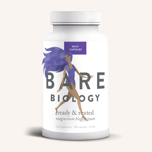 A white bottle of Bare Biology Magnesium Bisglycinate Capsules, with a purple-haired woman running on the label, offers easy absorption and nervous system support.