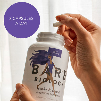 A hand holds a white bottle of Bare Biology Magnesium Bisglycinate Capsules, while the other hand holds a capsule above the open bottle. A purple circle reads 3 CAPSULES A DAY, highlighting easy absorption for your nervous system.
